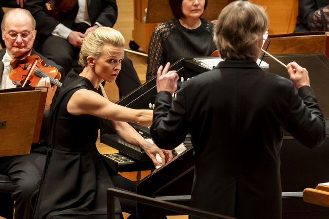 Closeup of Iveta Apkalna playing the organ while looking at Esa-Pekka Salonen