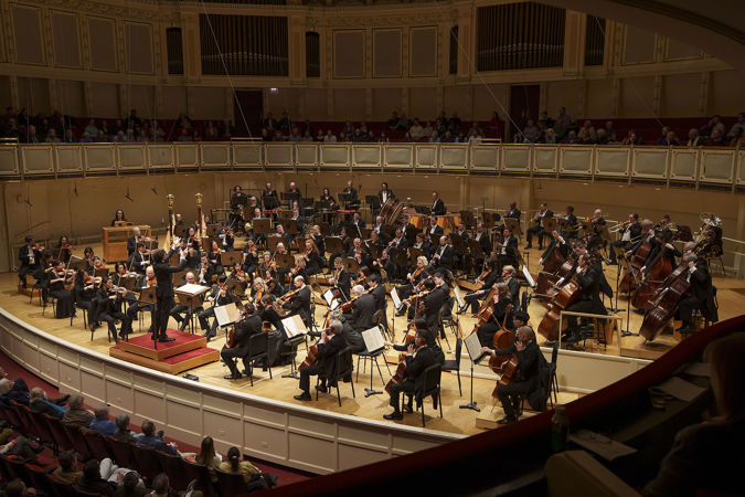 a view of the full Orchestra performing from the right side of the box level