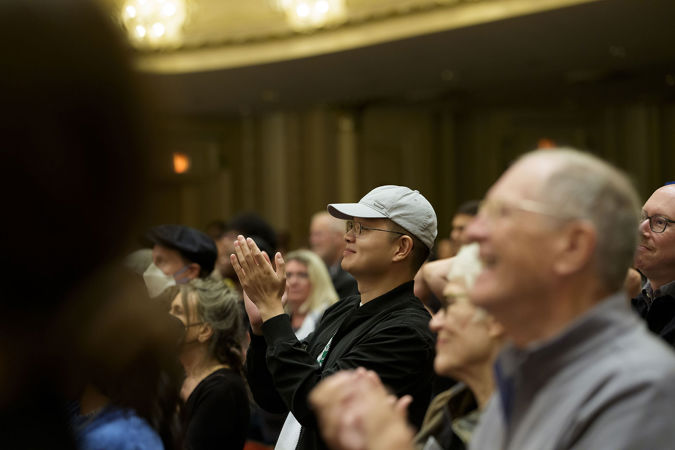 Closeup of a patron applauding all the musicians and Mikko Franck after the final note from the Main Floor