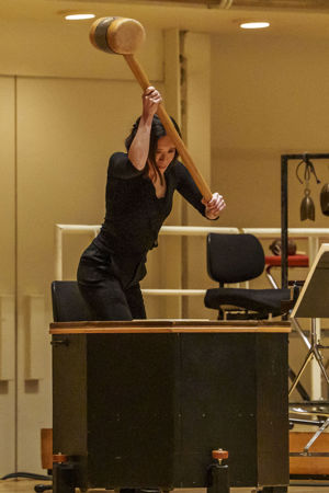 Closeup action shot of CSO principal percussion Cynthia Yeh raising the Mahler hammer on the drum in Mahler 6