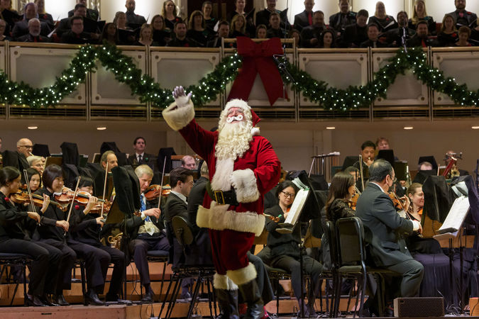 Closeup of Santa Claus on stage waving to the audience in Orchestra Hall