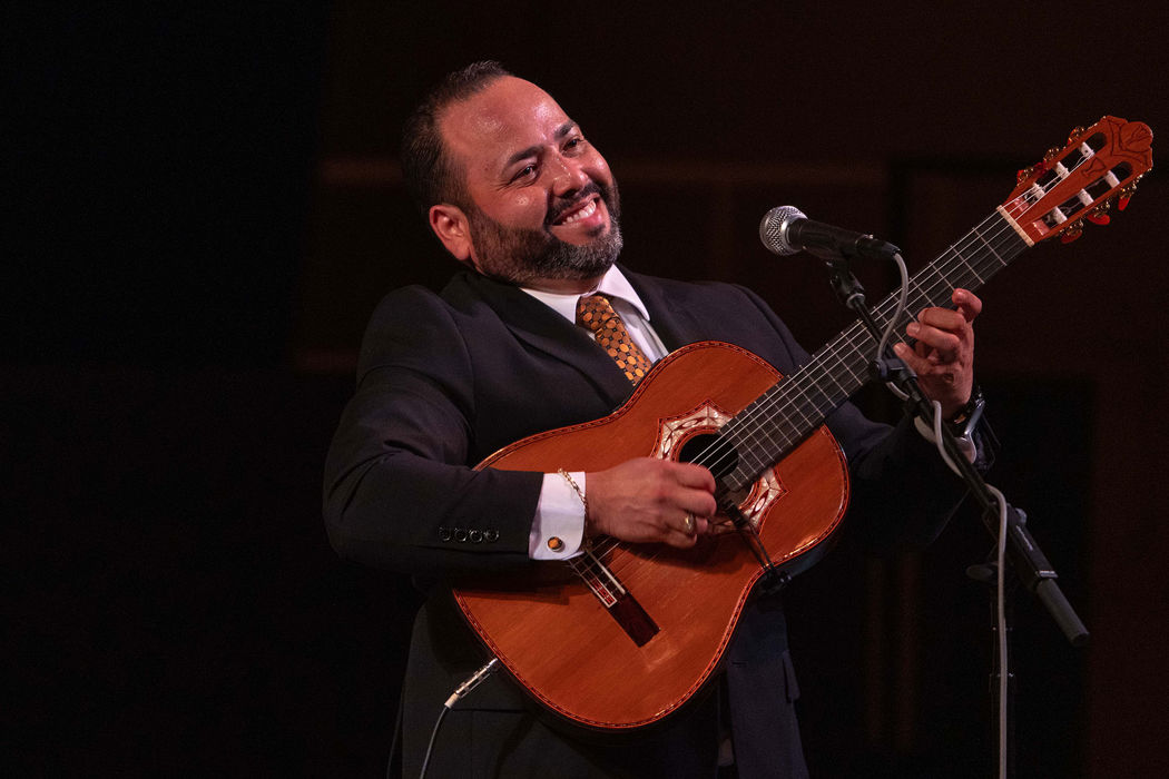 guitarist and vocalist Gabriel Rodriguez Ortiz, of the Puerto Rican-based group Trío Remembranza, smiles at the audience