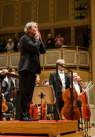 Esa-Pekka Salonen bows and blows air kisses to the crowd after a successful performance