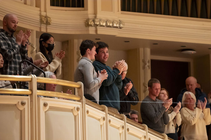 Audience members clapping from the terrace