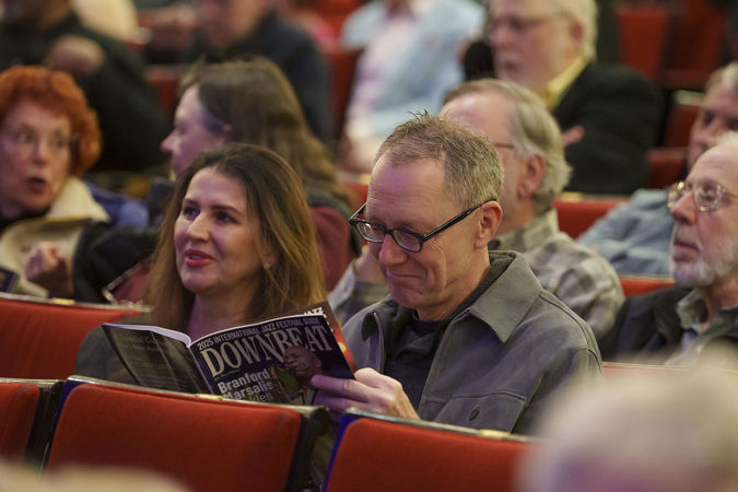 a couple in the audience passes time before the show by reading a copy of DownBeat jazz magazine