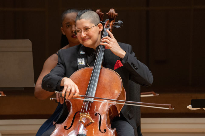 cellist Eri Snowden-Rodriguez smiles on stage