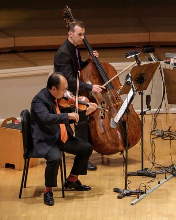 Closeup action shot of CSO musicians Robert Chen (violin) and Alexander Hanna performing on stage
