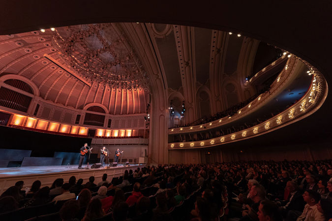 point of view from the left side of the main floor looking out over the stage, the audience, and the spectacular architecture of Orchestra Hall as Trío Remembranza performs