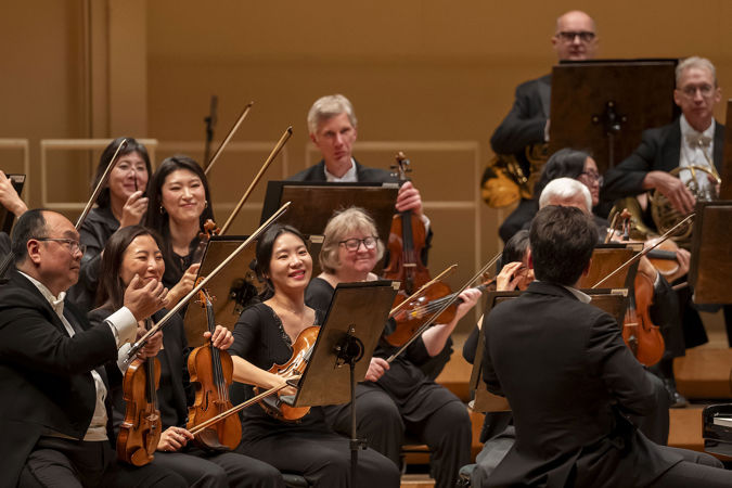 orchestra members applaud Shani