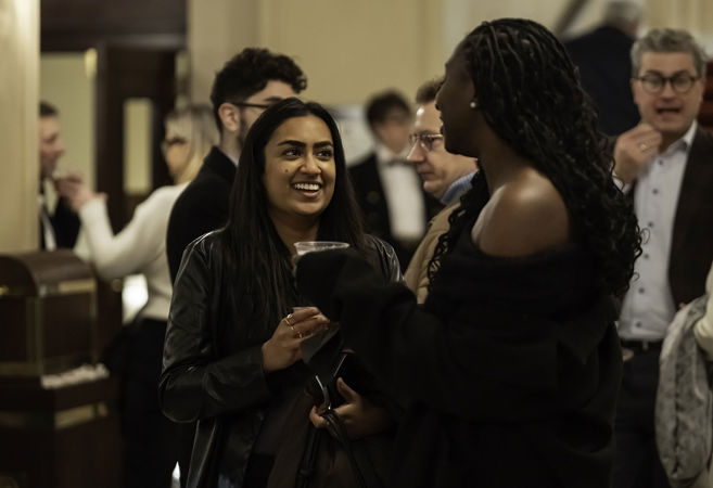 Closeup of two smiling patrons chatting in the Main Floor lobby