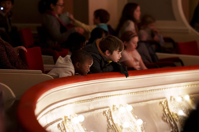 Close up of two young patrons watching the performance from the box level