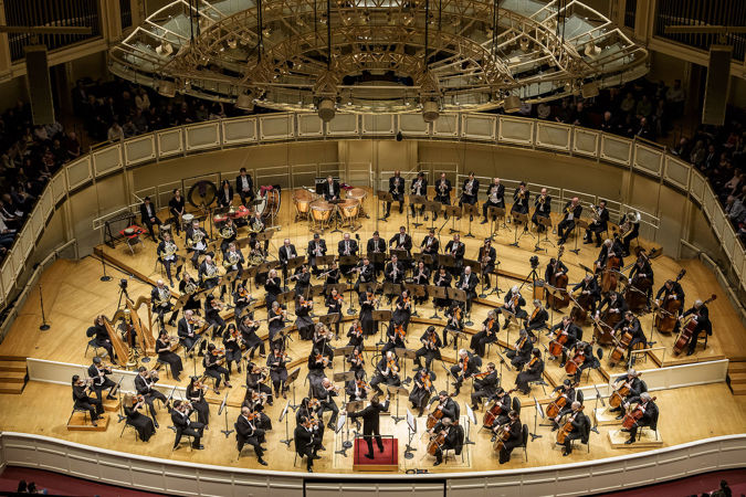 a wide shot from the lower balcony of Mäkelä and the Orchestra mid-performance