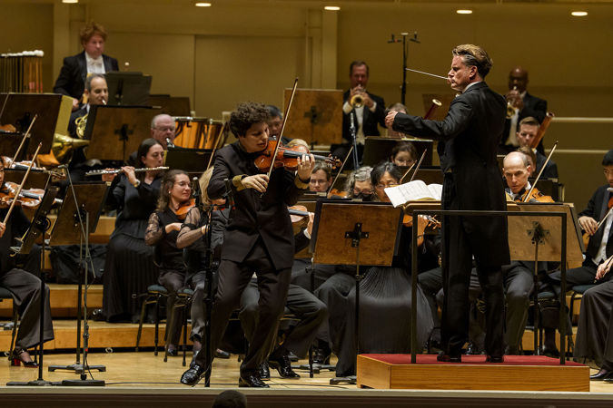 Closeup action shot of violin Augustin Hadelich performing on stage
